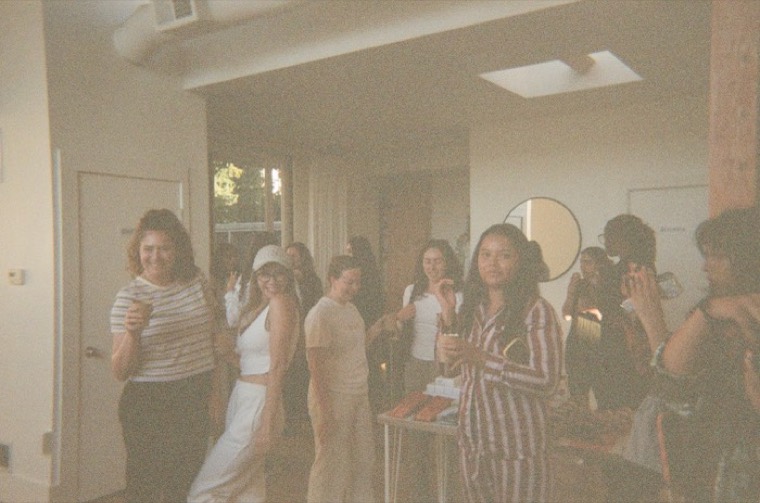 A room of women in pajamas mingling at a Cherry event